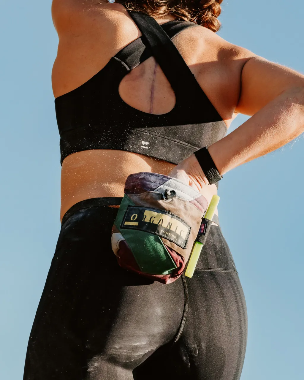 Athlete in black sportswear wears a colorful waist pack at the back.