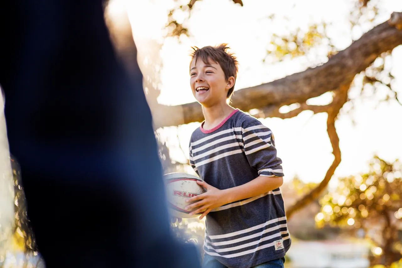 New Zealand school child outdoors under a tree