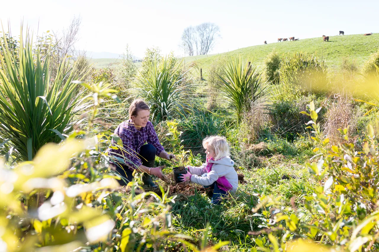 Mum and daugher plant a native tree