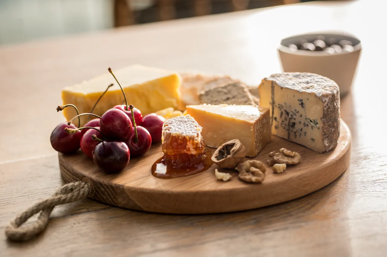 Cheese board with honey, walnuts and cherries