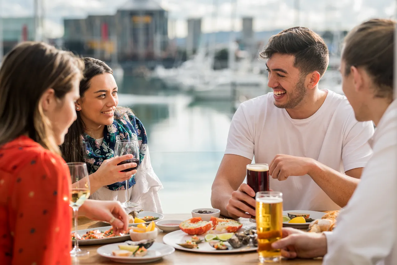 Young friends dining on seafood at a waterfront bar