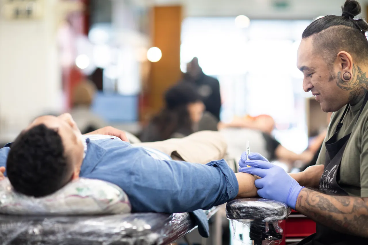 Tattoo artist talks to his customer