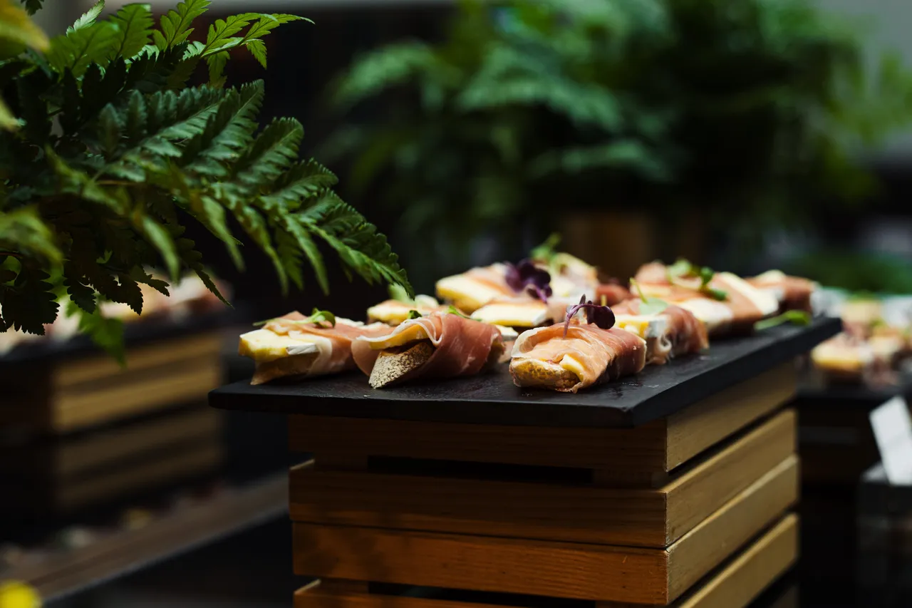 Plated cheese topped with prosciutto and microgreens 