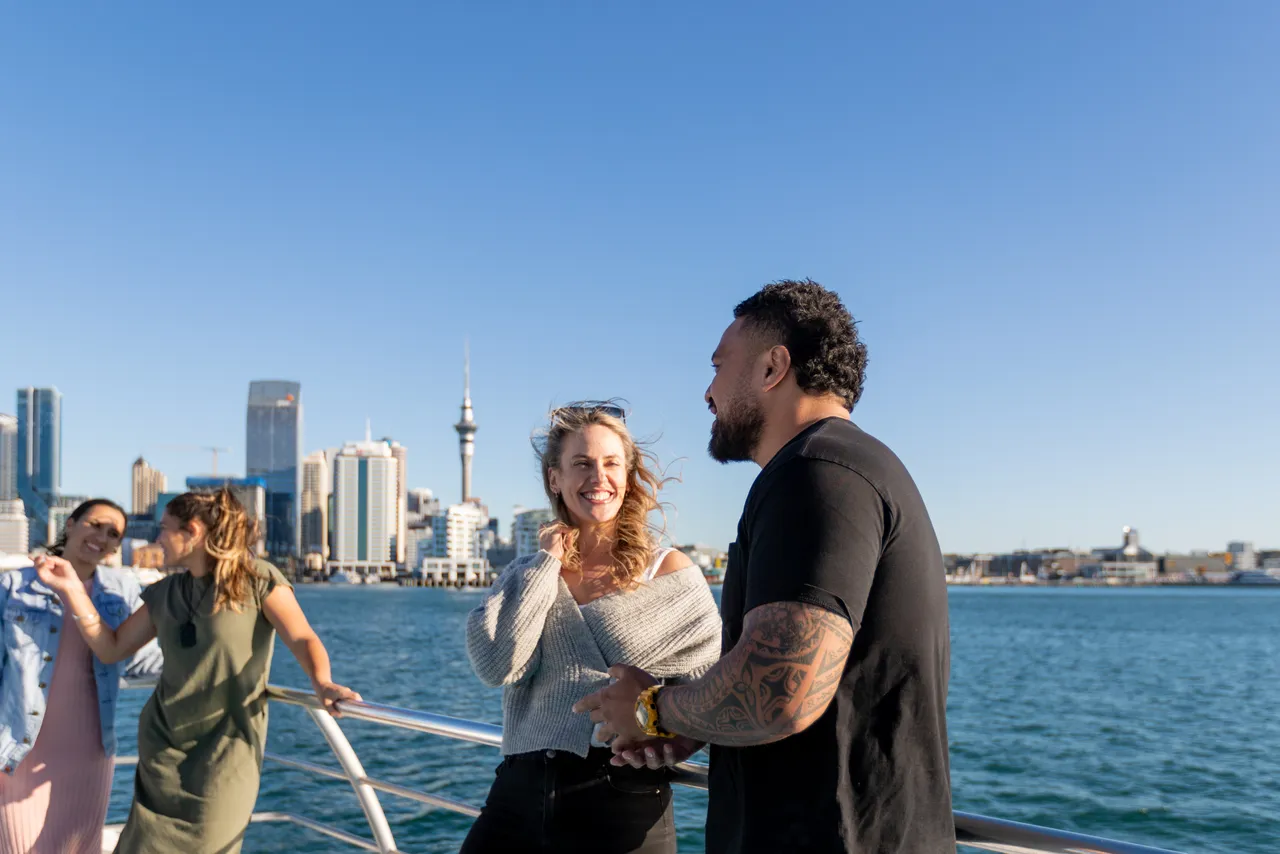 Group hangout on deck of boat with City behind them
