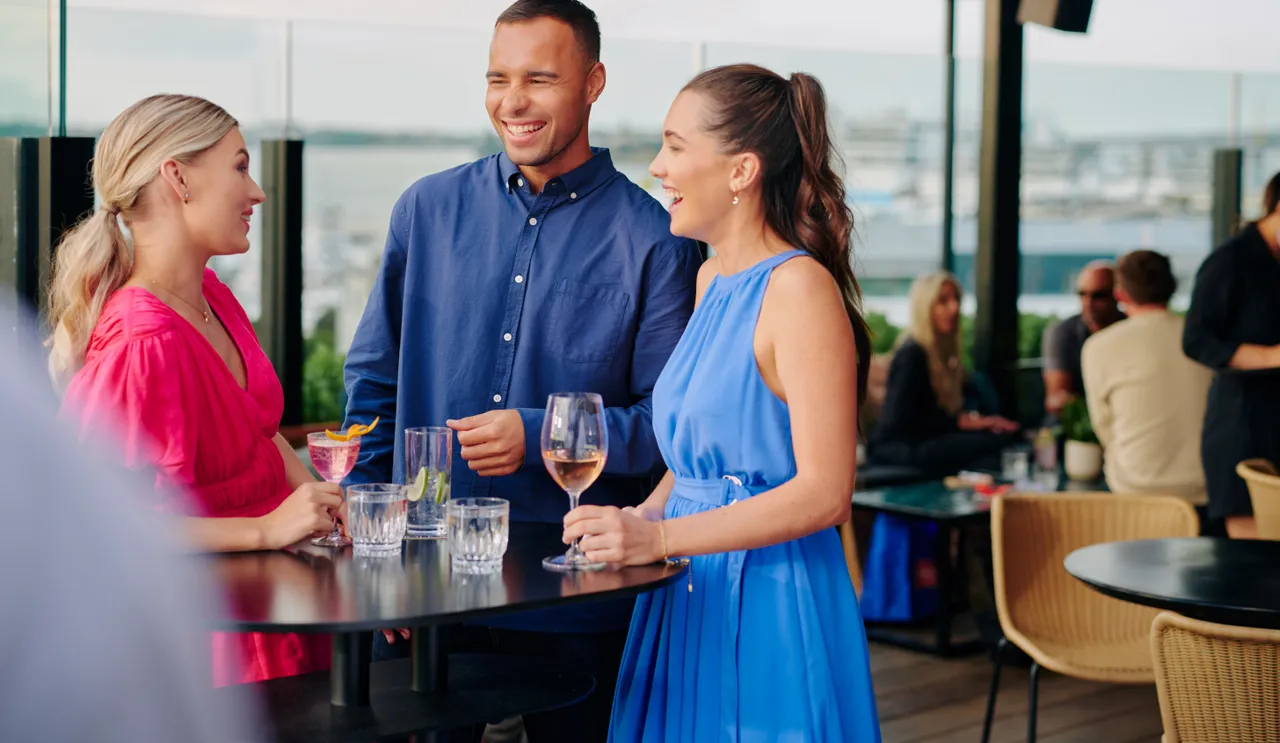 Young adults laugh while having a drink at bar
