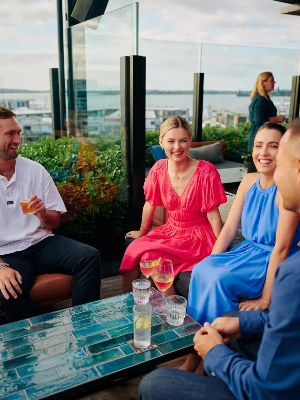 Group of friends having a drink with Waitematā Harbour in the background