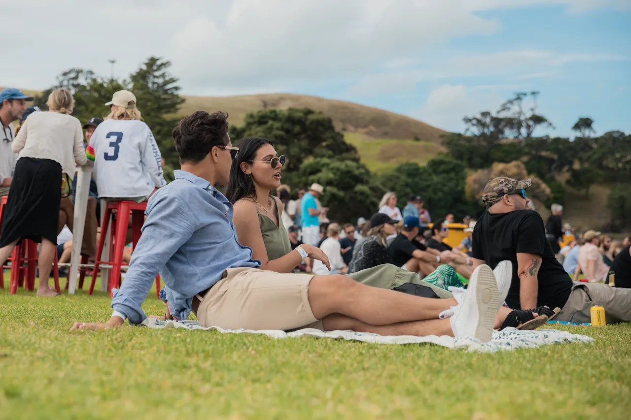 Couple sitting down amongst crowd at festival
