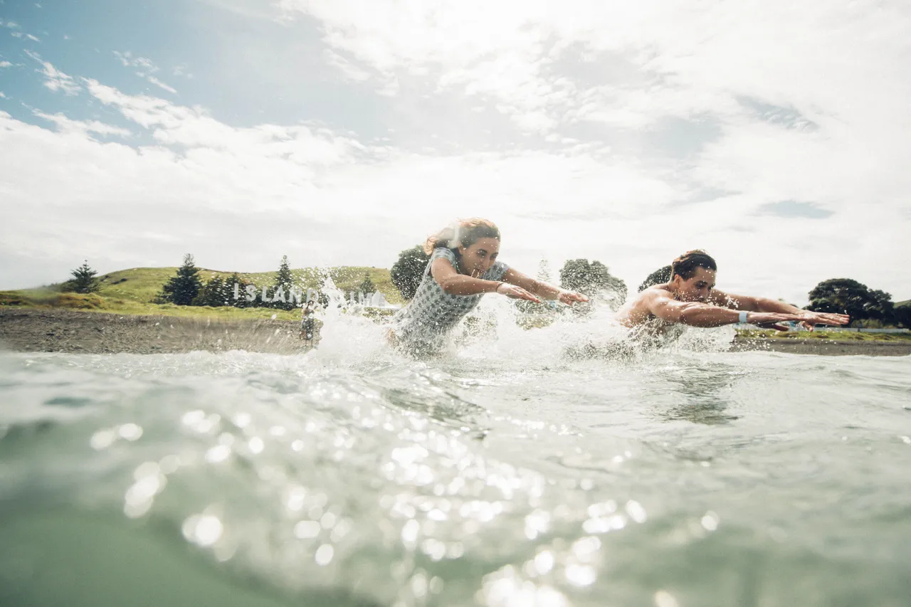 Man and woman diving into the ocean