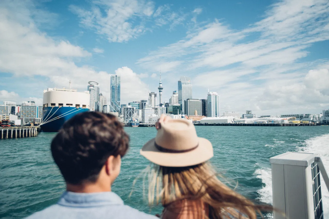 Man and woman admiring Auckland City while on a boat