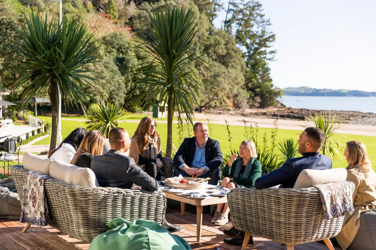 Group of delegates sitting in the sunshine on deck