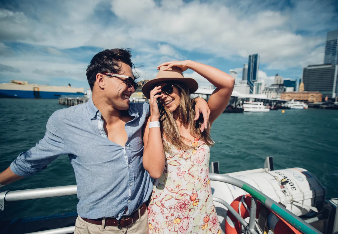 Happy couple on boat Auckland CBD in background