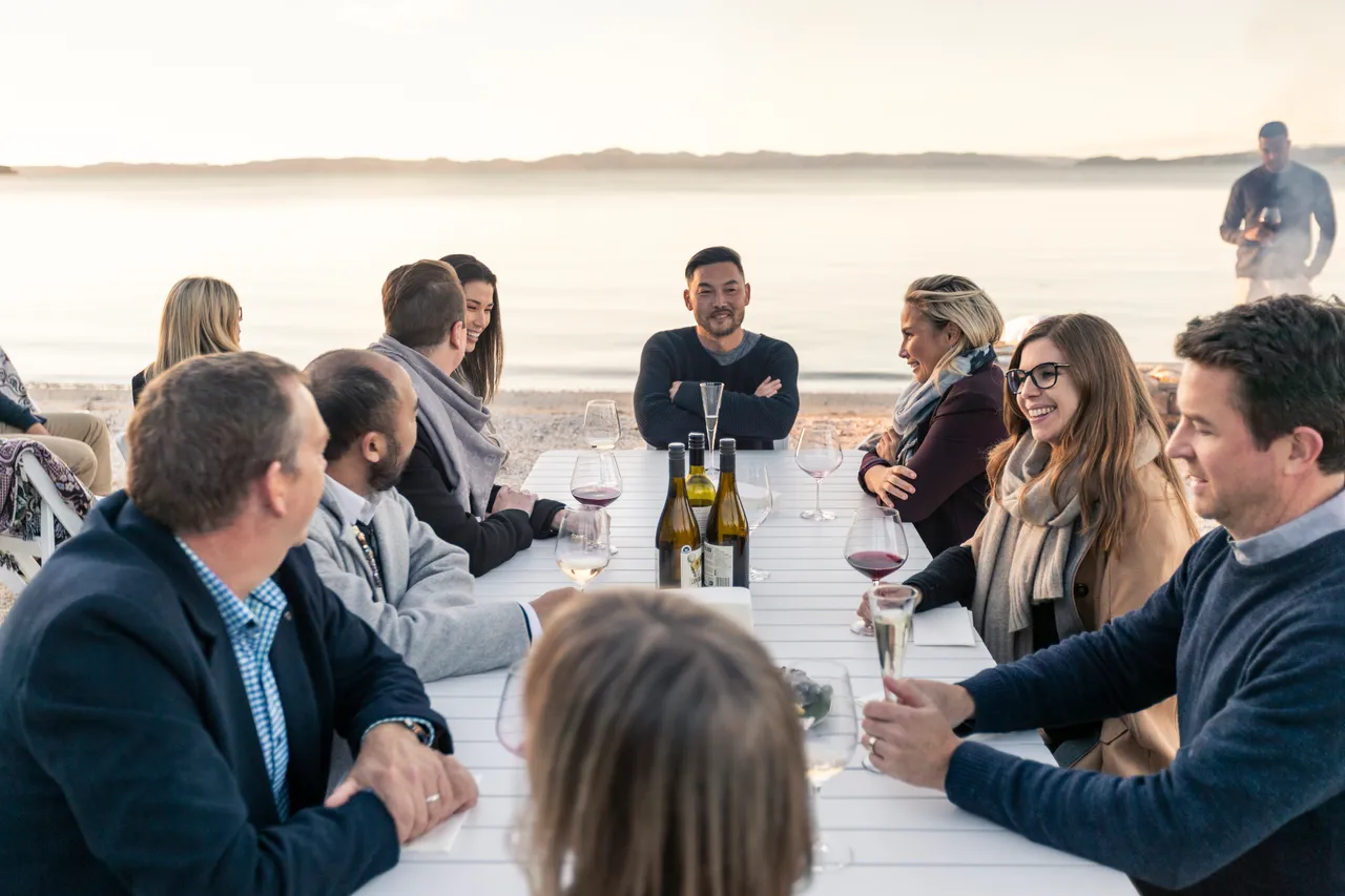 Delegates sitting at table on beach