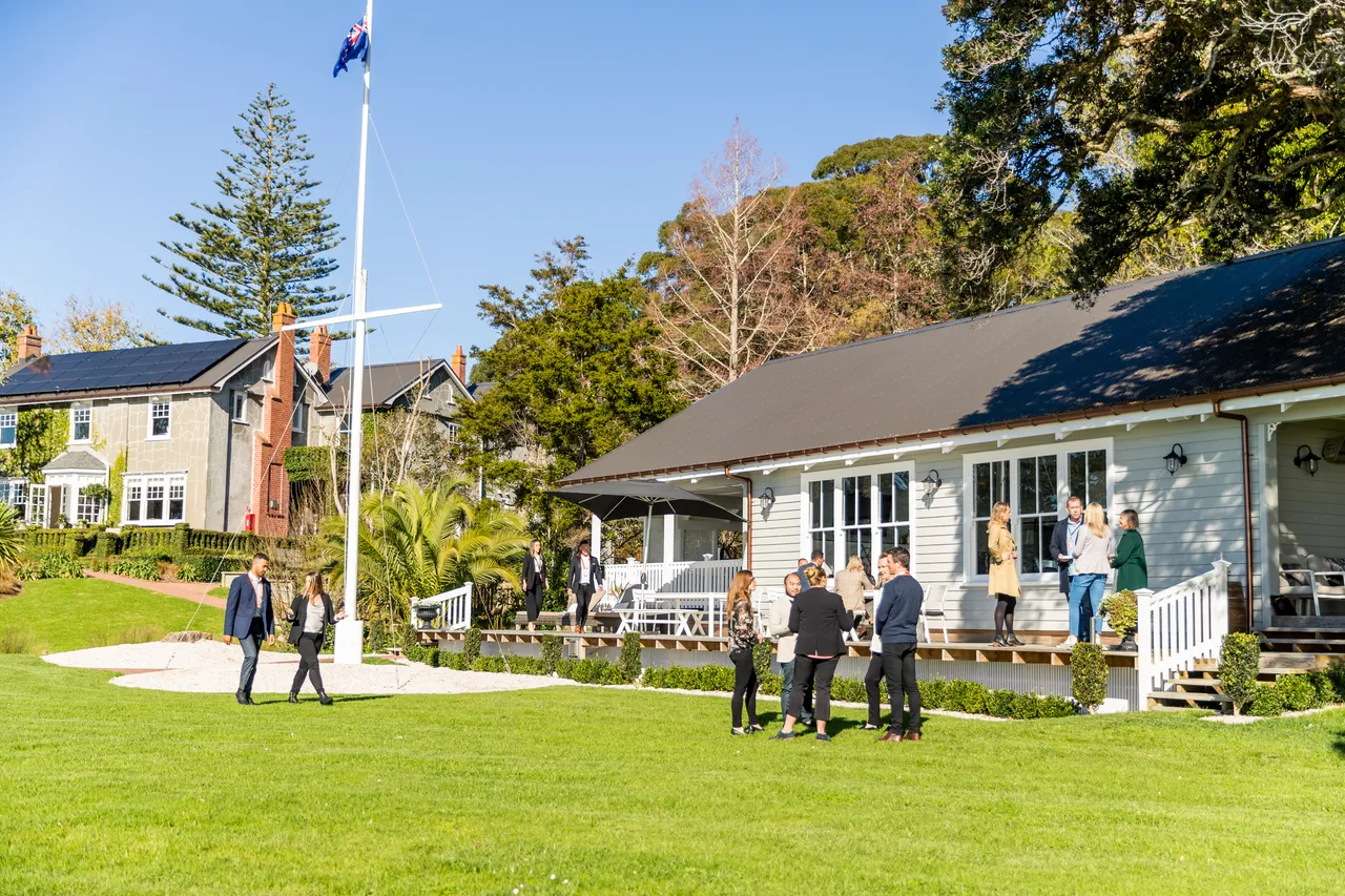 Delegates interact in front of boathouse