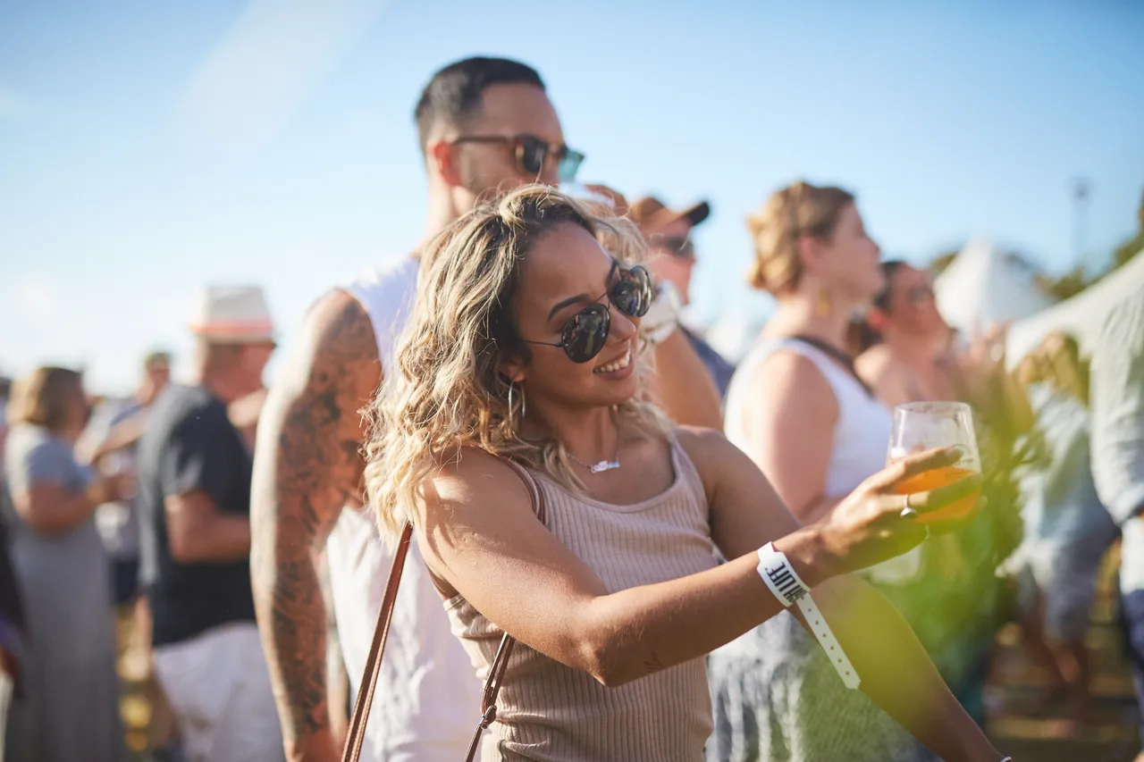 Woman dancing while holding a drink in crowd
