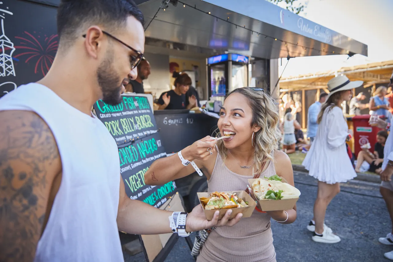 Man and woman enjoying food at festival