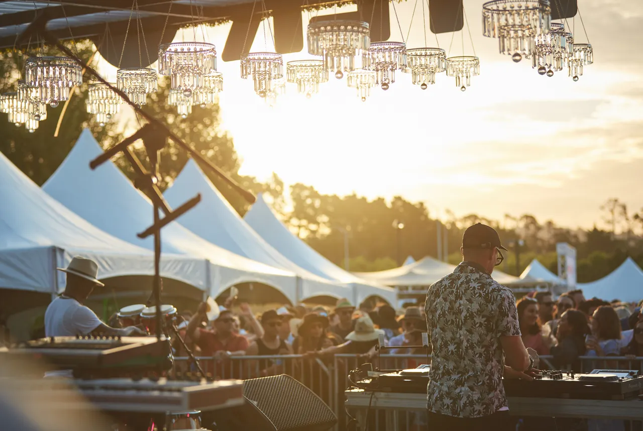 DJ performing to crowd at outside festival