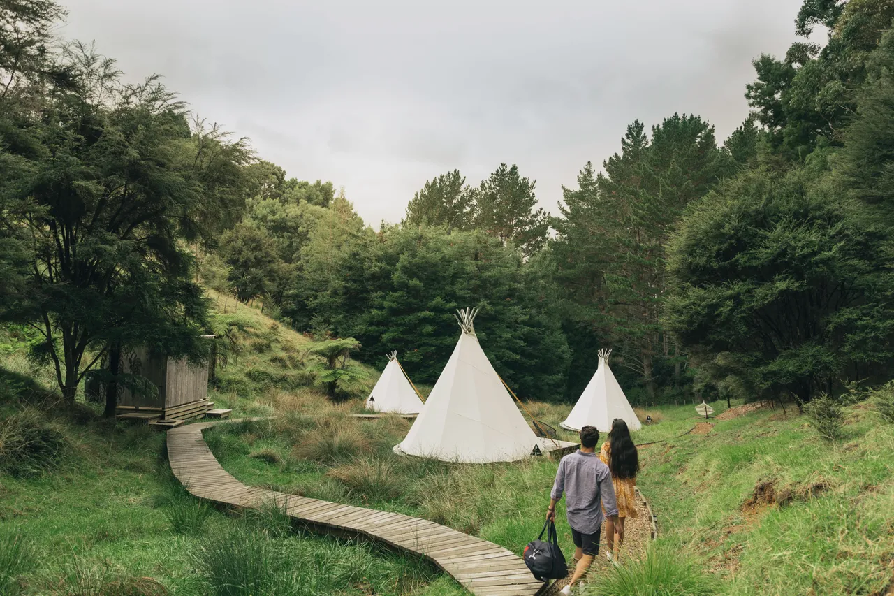 Man and woman arriving at a glamping tent
