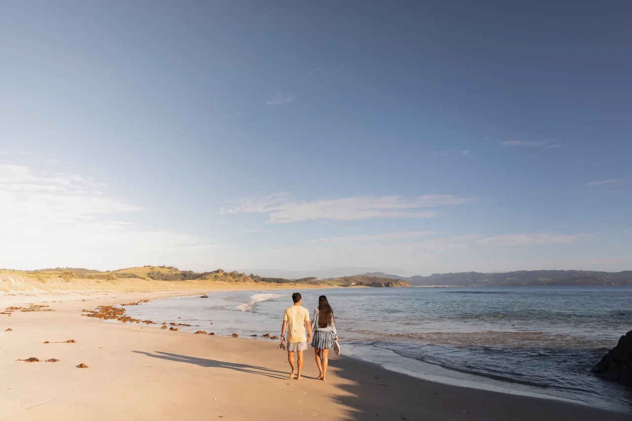 Man and woman walking along a beach