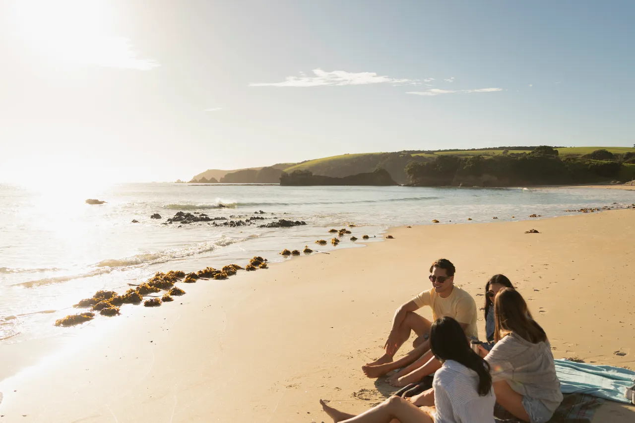 Four people sitting on beach