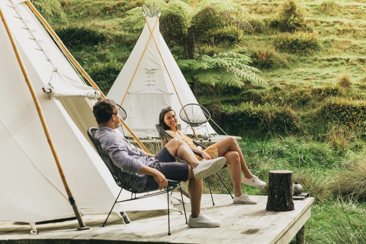 Couple sitting outside a glamping tent