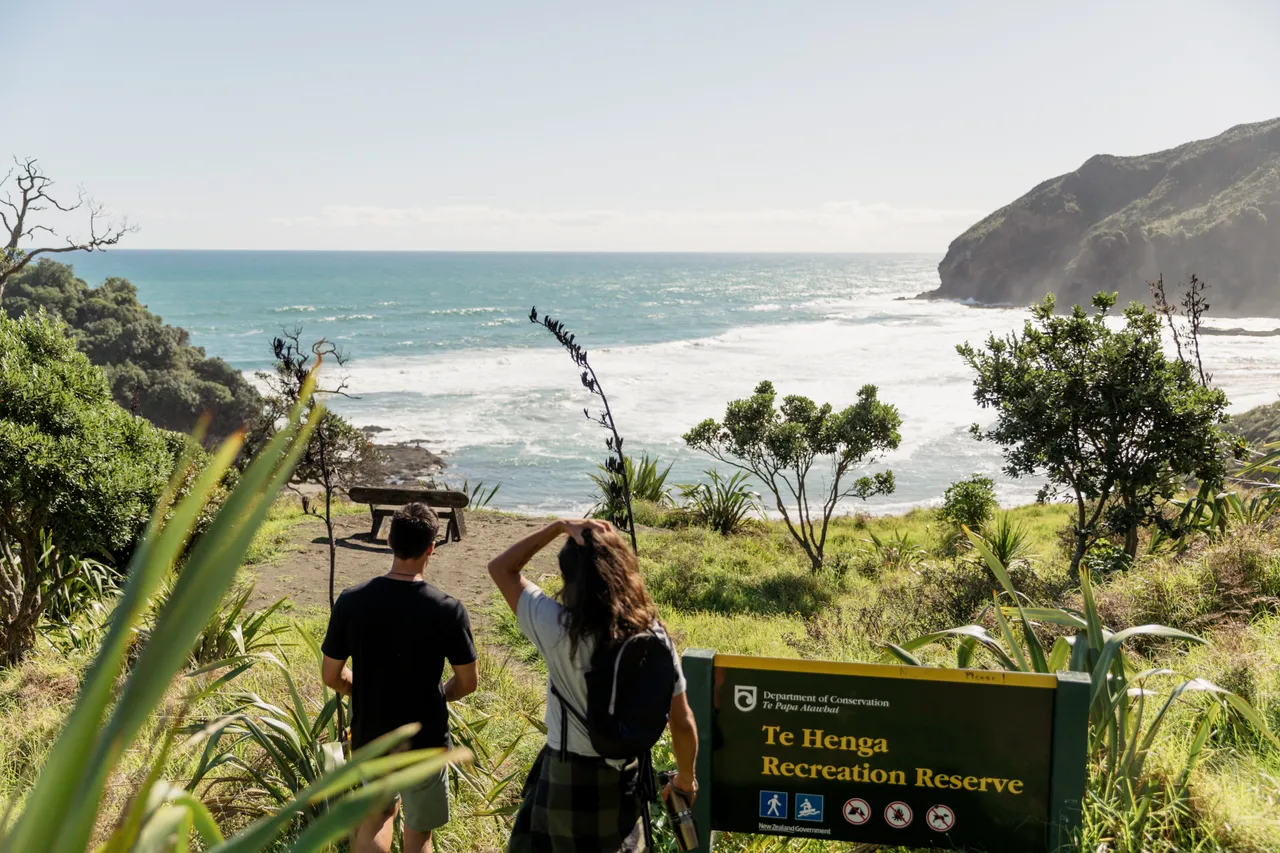 Two people walking along coastal track