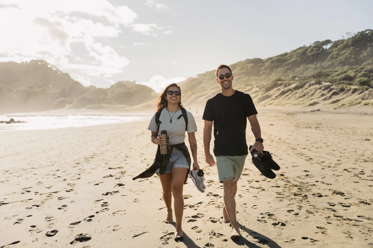 Woman and man walking along beach