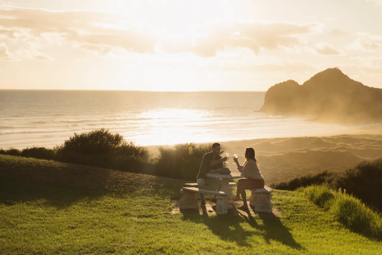 Man and woman sitting at a table by the beach