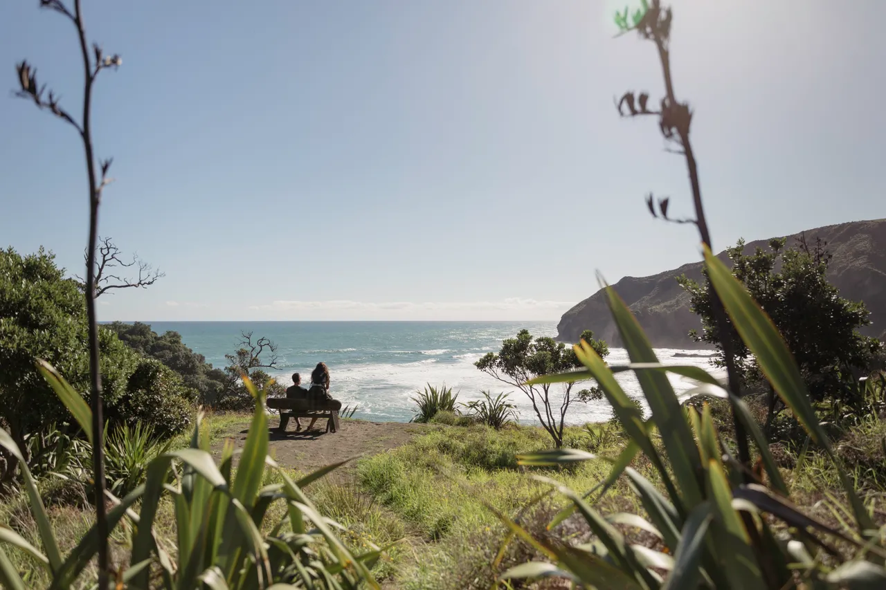 Couple sitting on bench at the beach