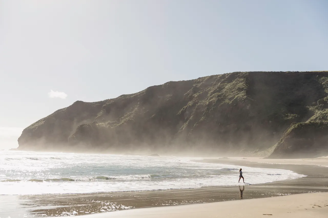 Beach landscape with woman in shallow water
