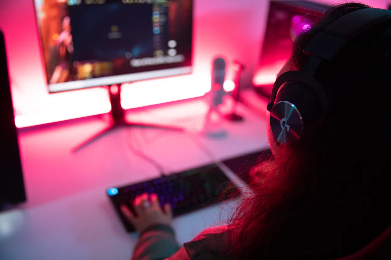 Woman with headphones with computer screen in background