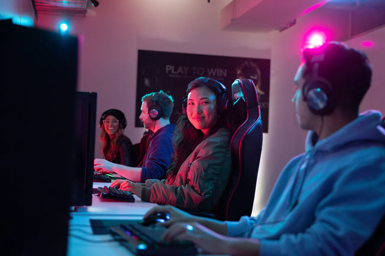 Group of young men and women playing games on computer