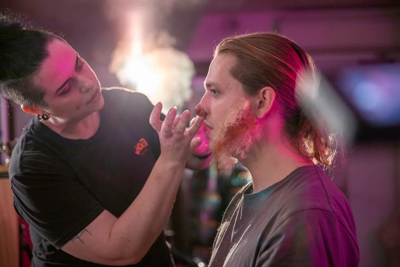 Woman putting on prosthetics on actor backstage
