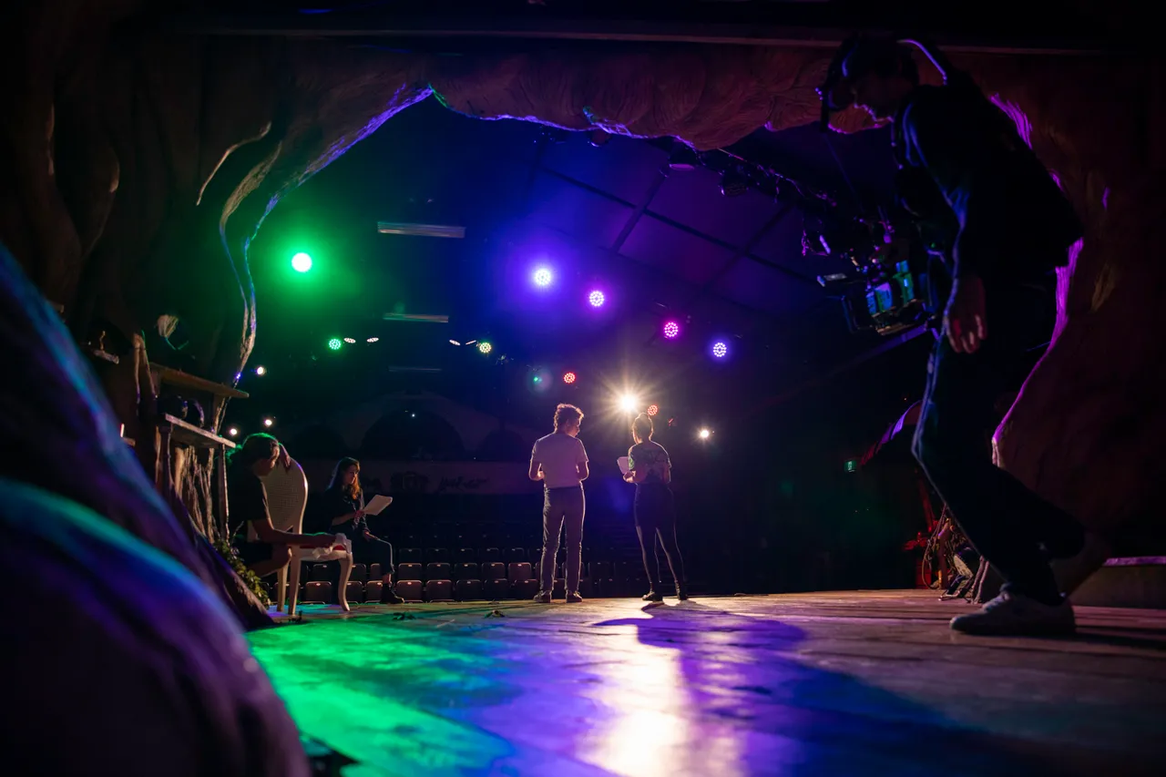 Actors on stage while cameraman crosses the stage