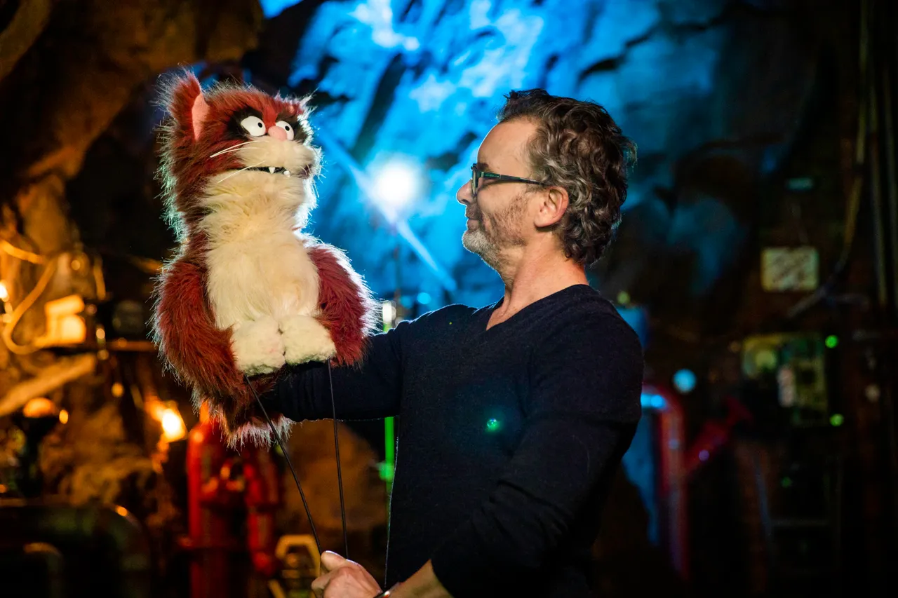 A puppeteer and his puppet on his hand