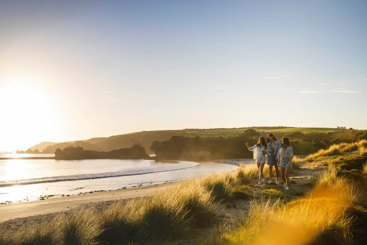 Three women standing on sand dunes