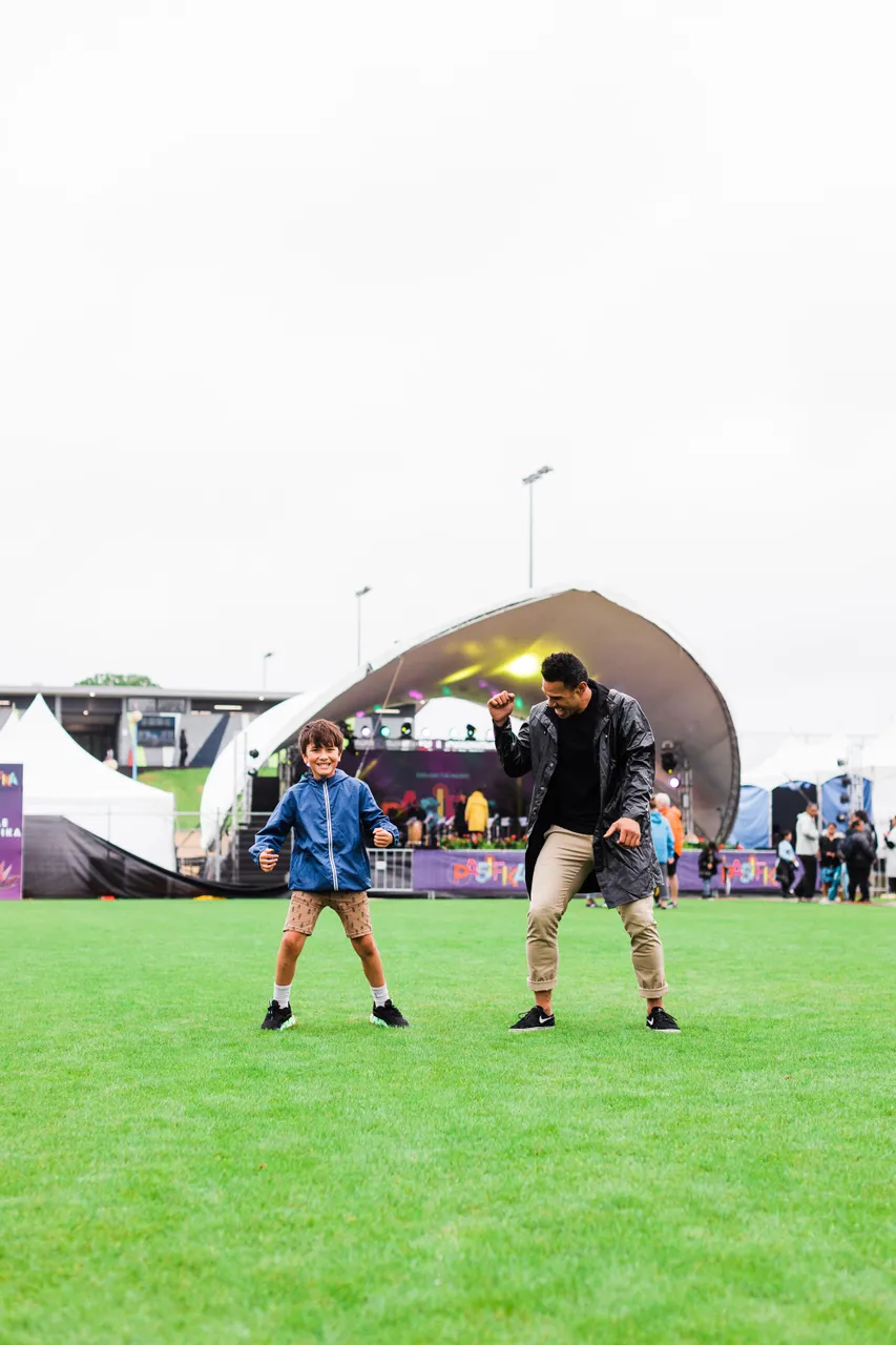 Man and child dancing in front of stage