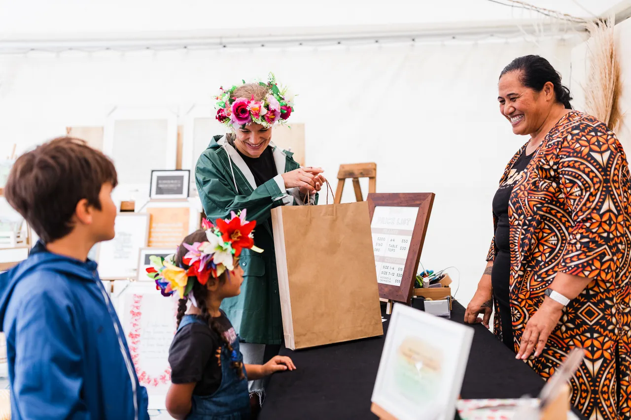 Family with two young kids purchase products from Pasifika stall