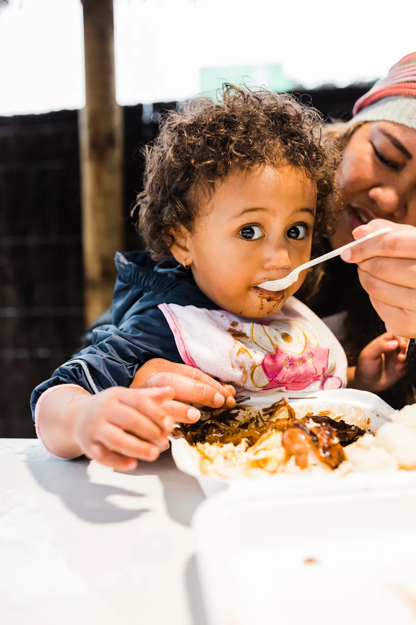 Young child being fed chop suey
