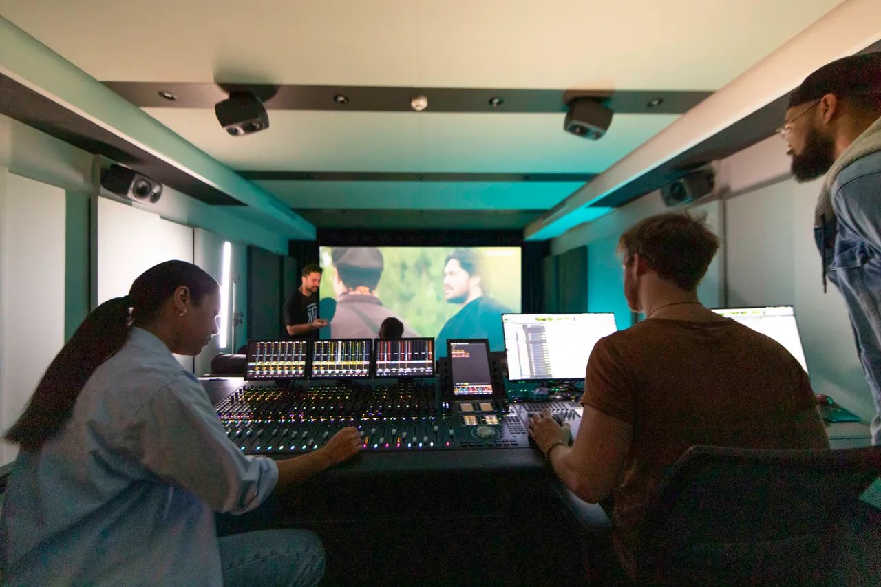 Group working in editing suite with people in viewing theatre