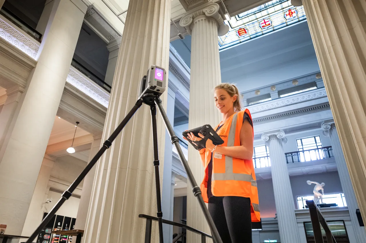 Woman working on tablet next to 3D scanner