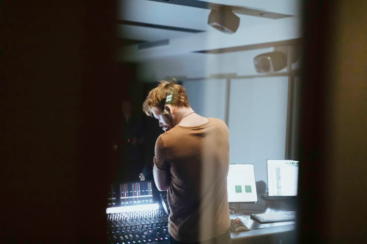 Man in thought in front of editing desk
