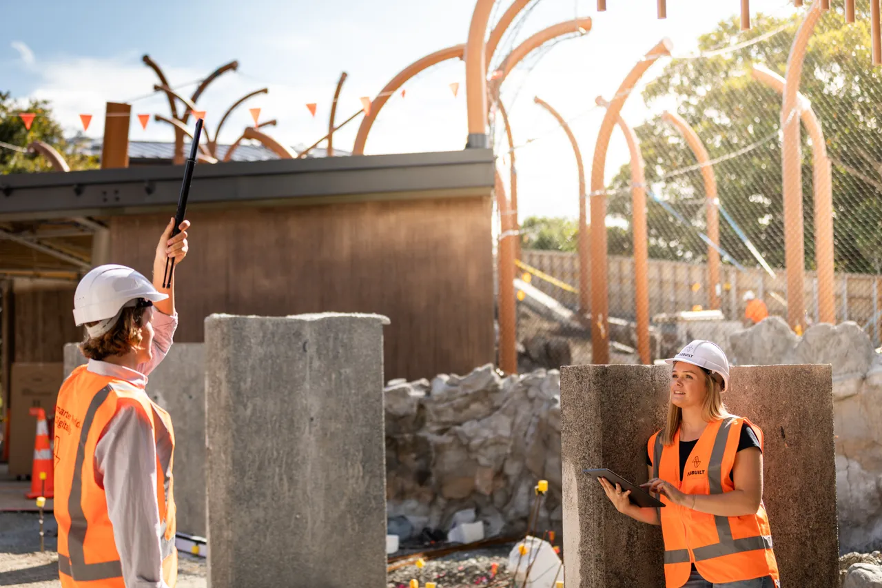 Woman and man working on construction site using 360 camera