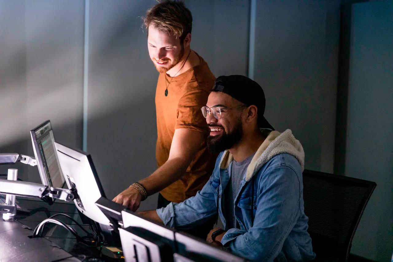 Two men working on computers in studio