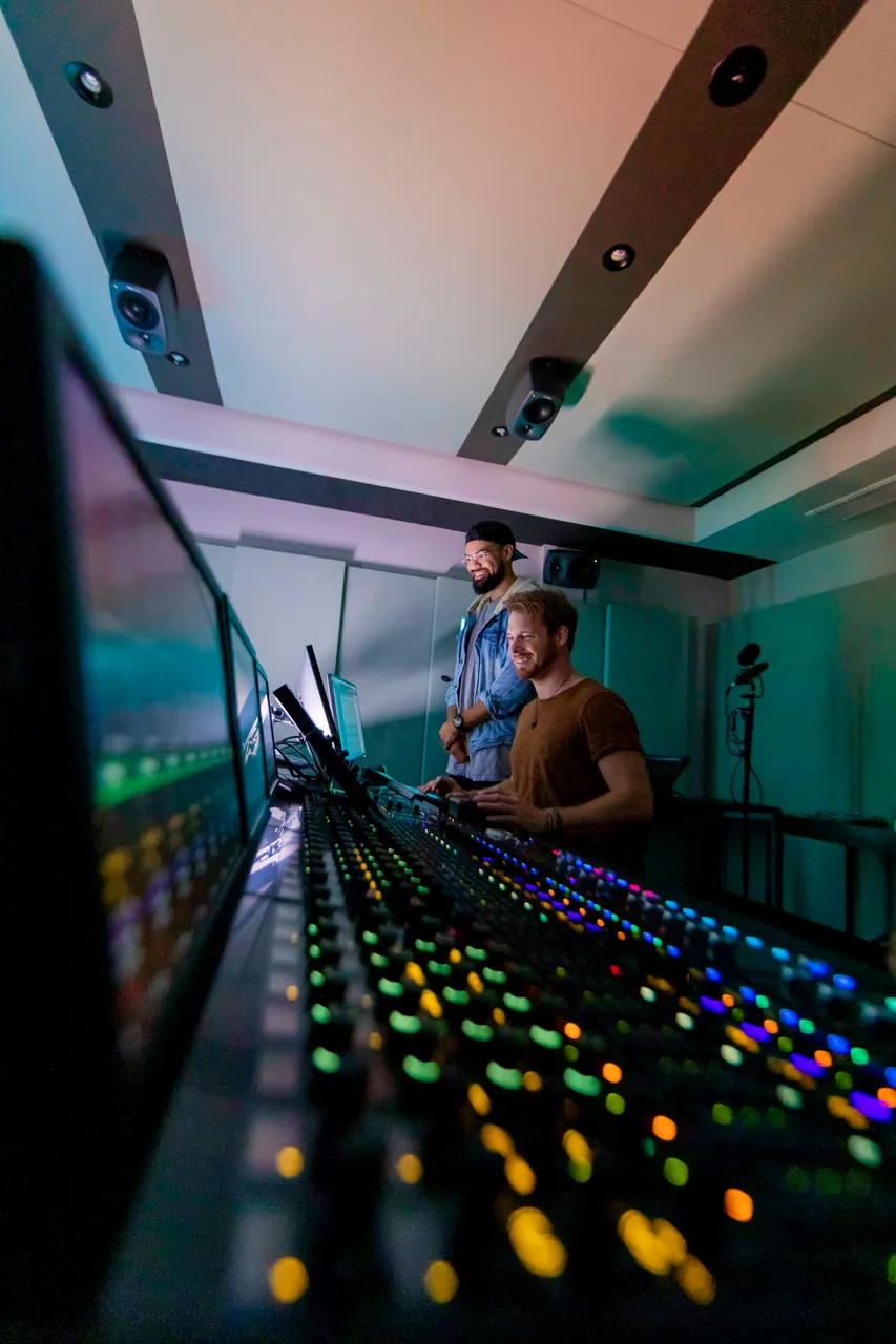Two men working on editing desk in studio