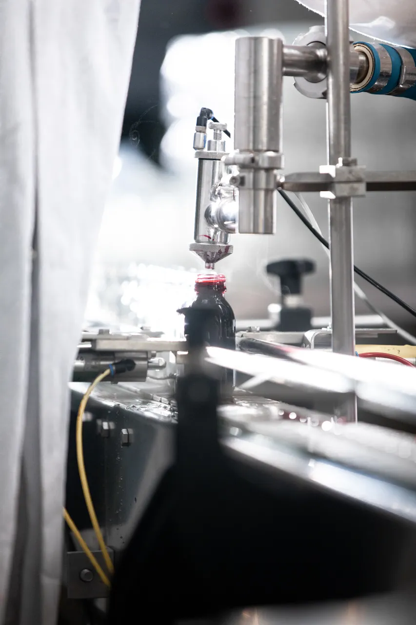 Bottle being filled in production factory