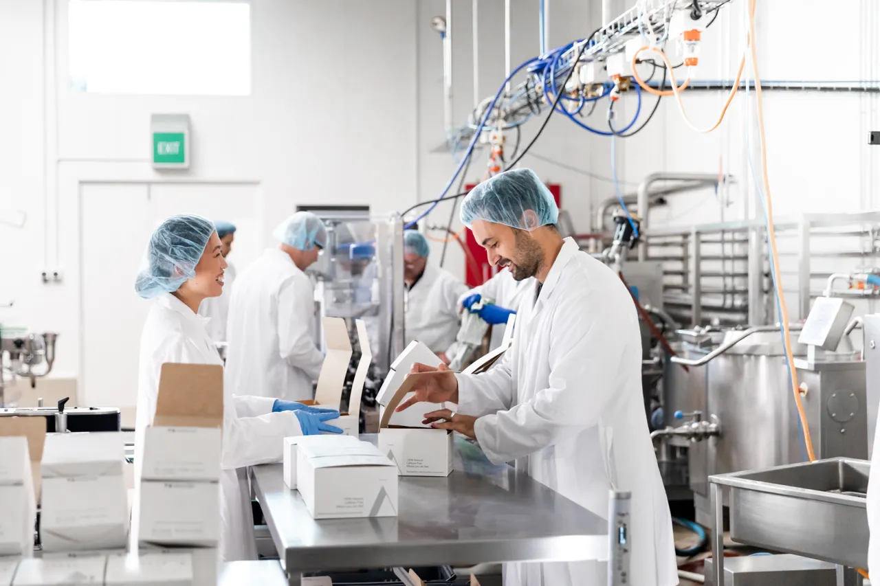 Woman and man handling product in production facility