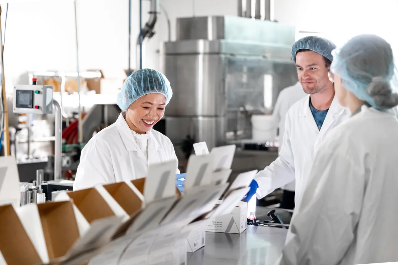 Woman and man packing in production factory