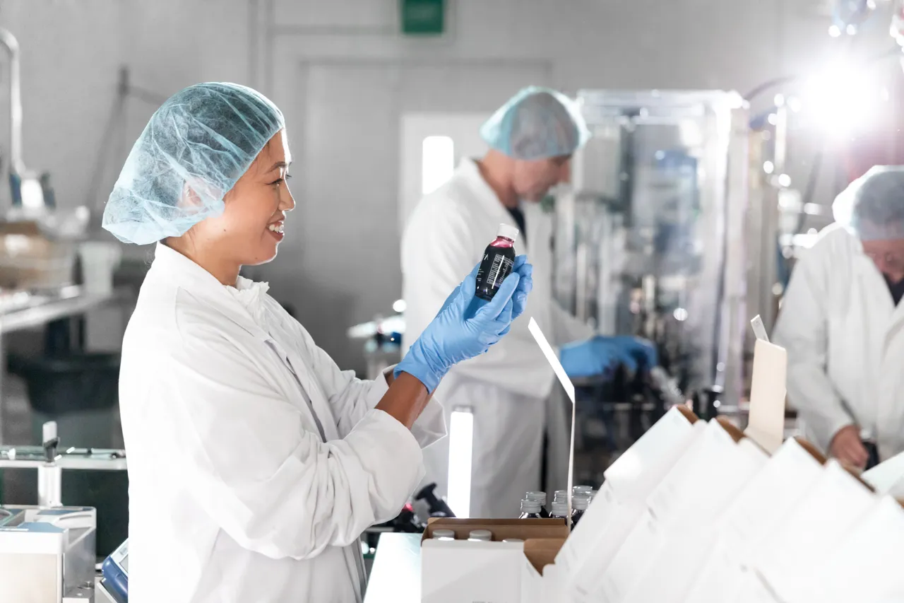 Woman working in factory with workers in background