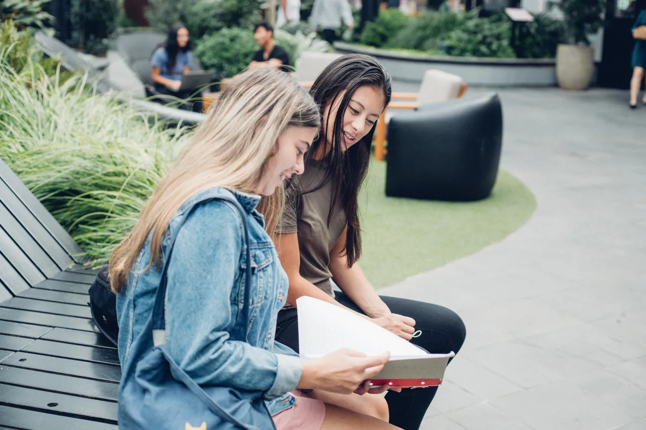 Two girls looking at a note pad