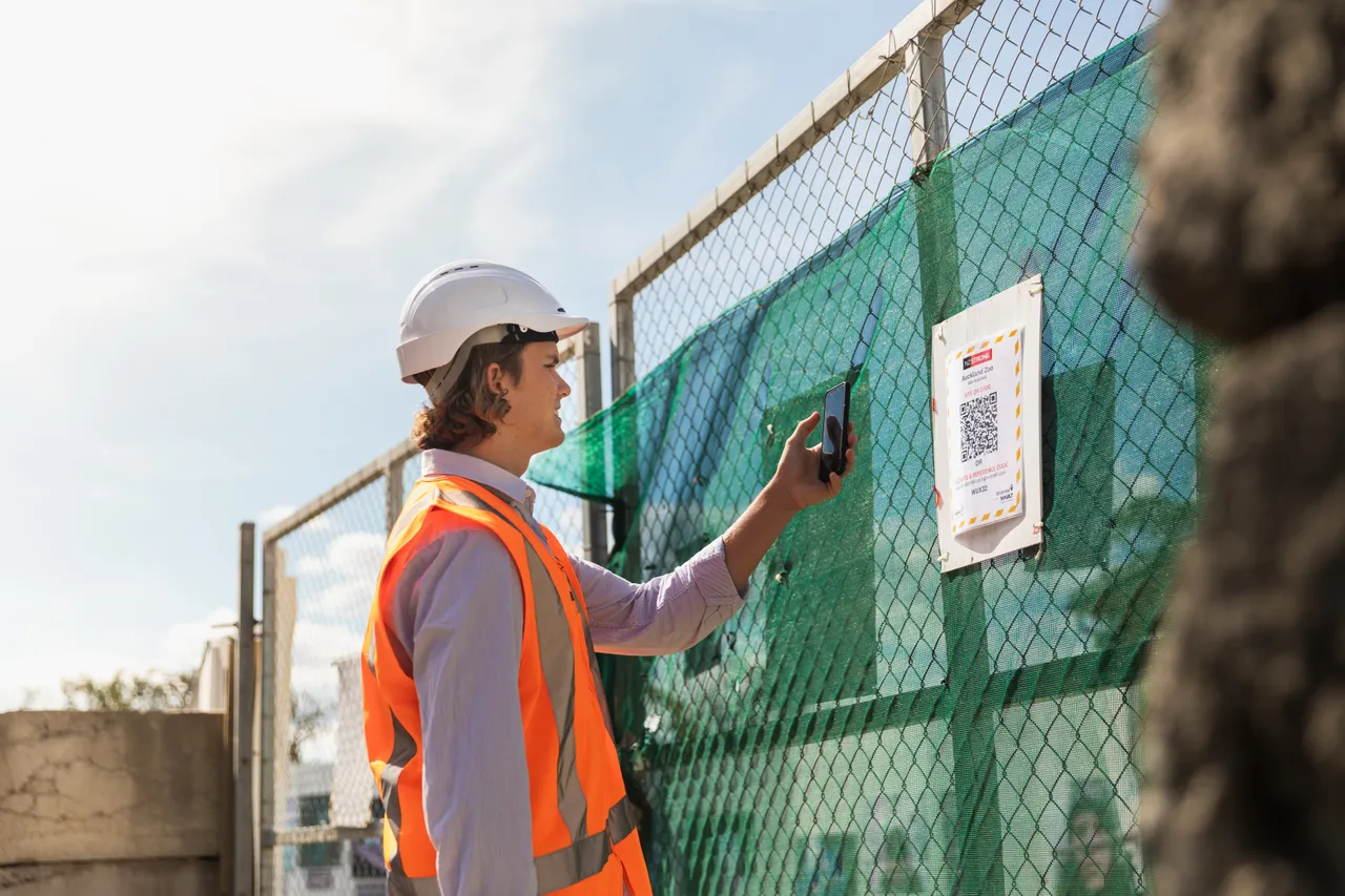 Man on work site using covid app